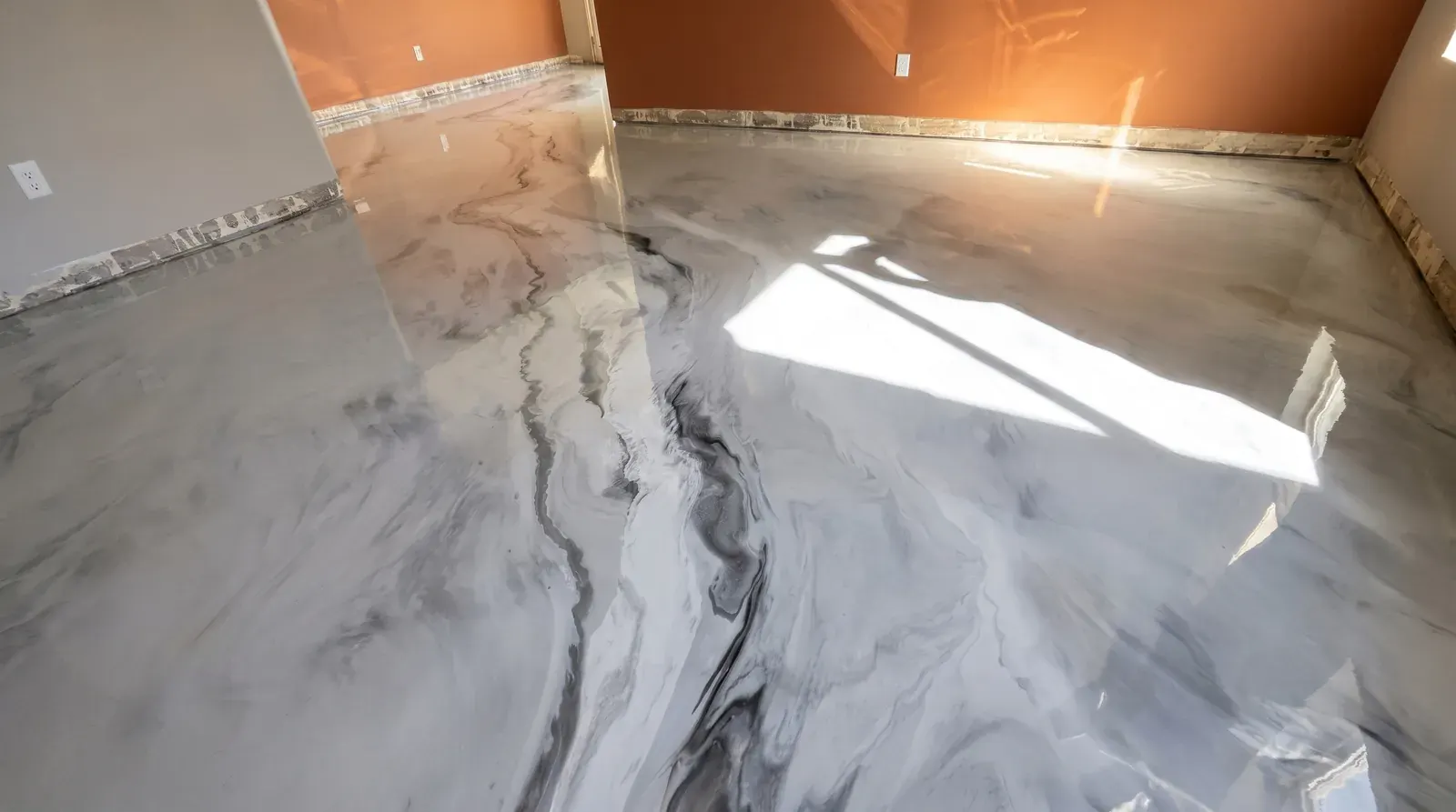 Piso metálico marmoleado blanco con vetas grises que refleja la luz de una ventana